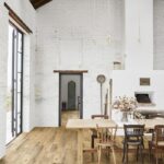 photo d'une pièce aux murs hauts et chaulés de blanc, avec luminaires épurés et mobilier style campagne chic.