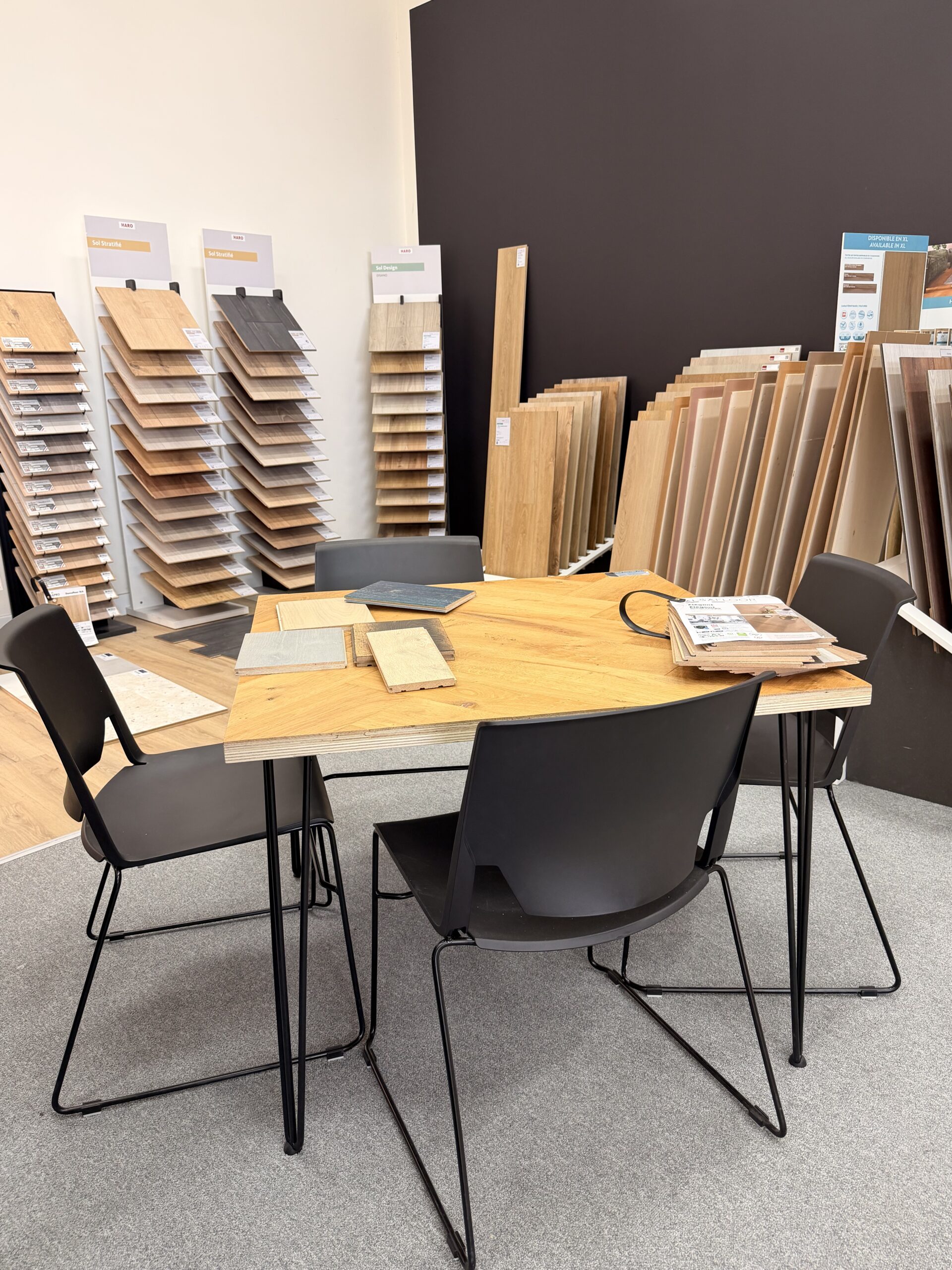 photo d'une table avec quatre chaises entourée d'échantillons de revêtements de sols dans un showroom