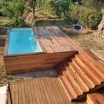 photo d'une piscine entourée d'une terrasse neuve avec un grand escalier pour atteindre l'eau
